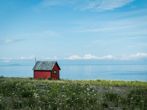 red wooden house near body of water during daytime