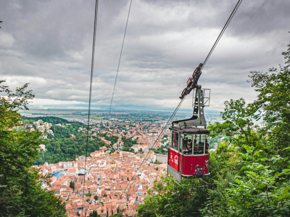 red cable car over city buildings during daytime