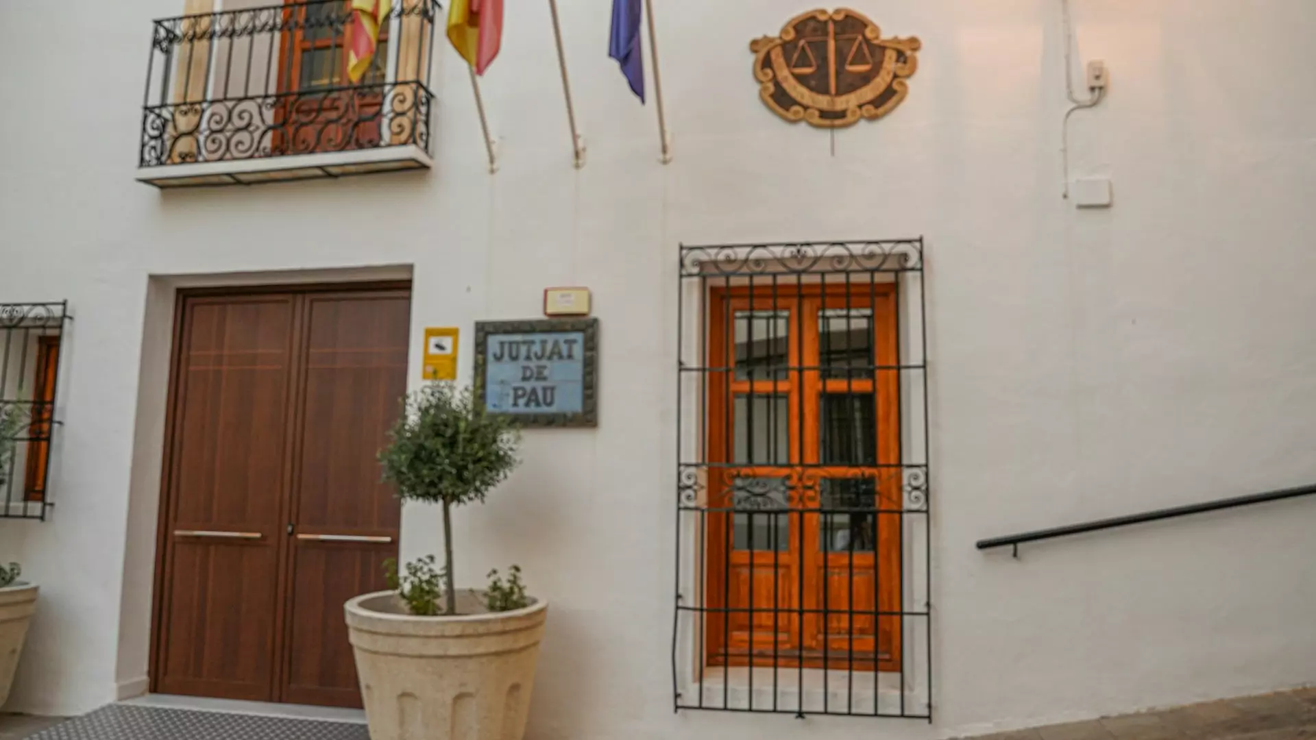 a door with a gate and a planter with flags on it