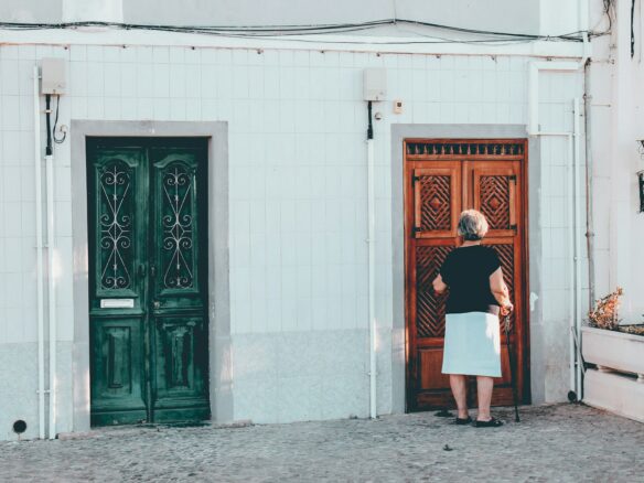 woman in black and white dress standing in front of brown wooden door