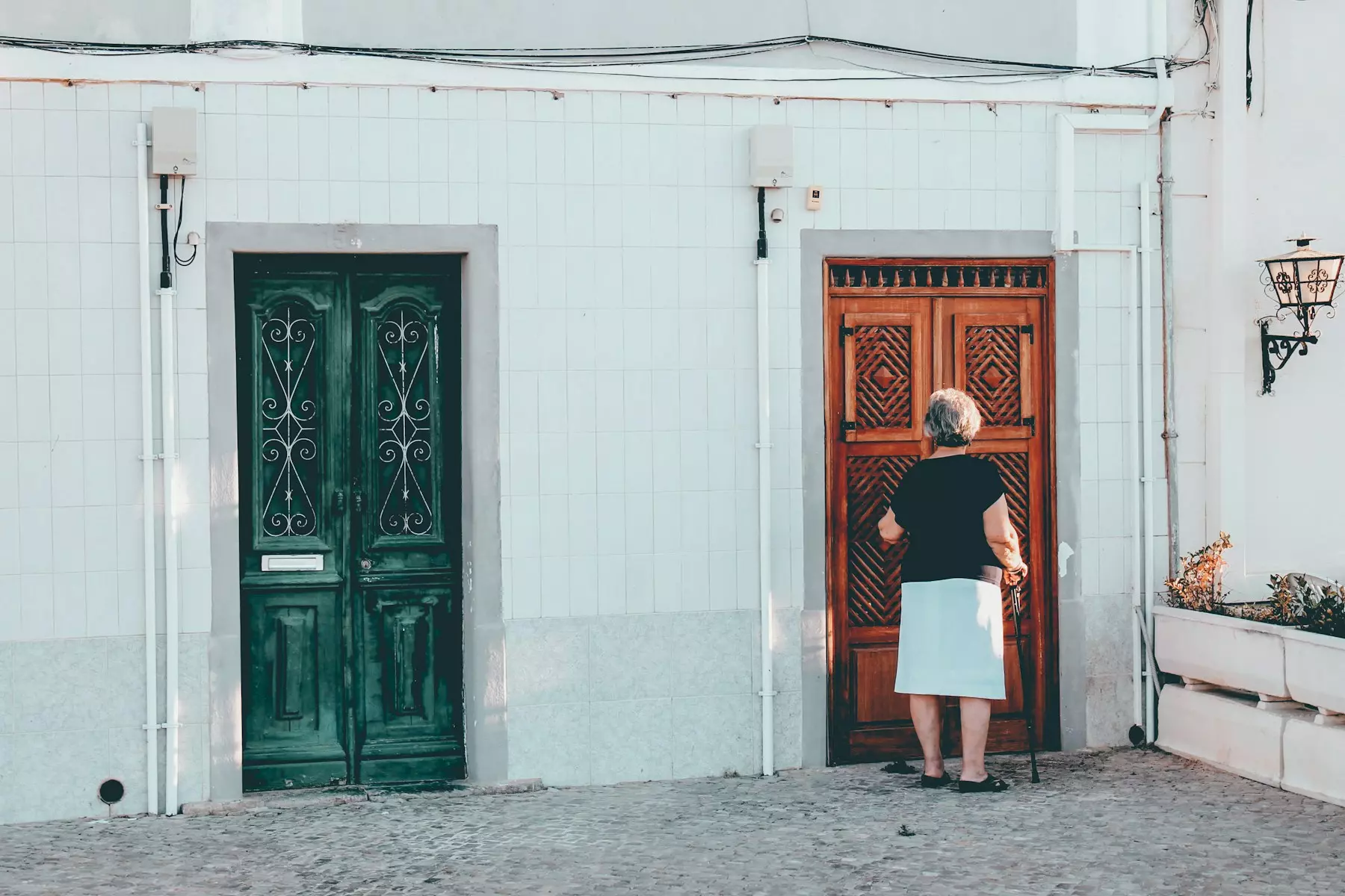 woman in black and white dress standing in front of brown wooden door