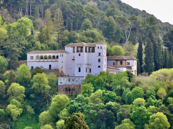 white concrete building surrounded by green trees during daytime