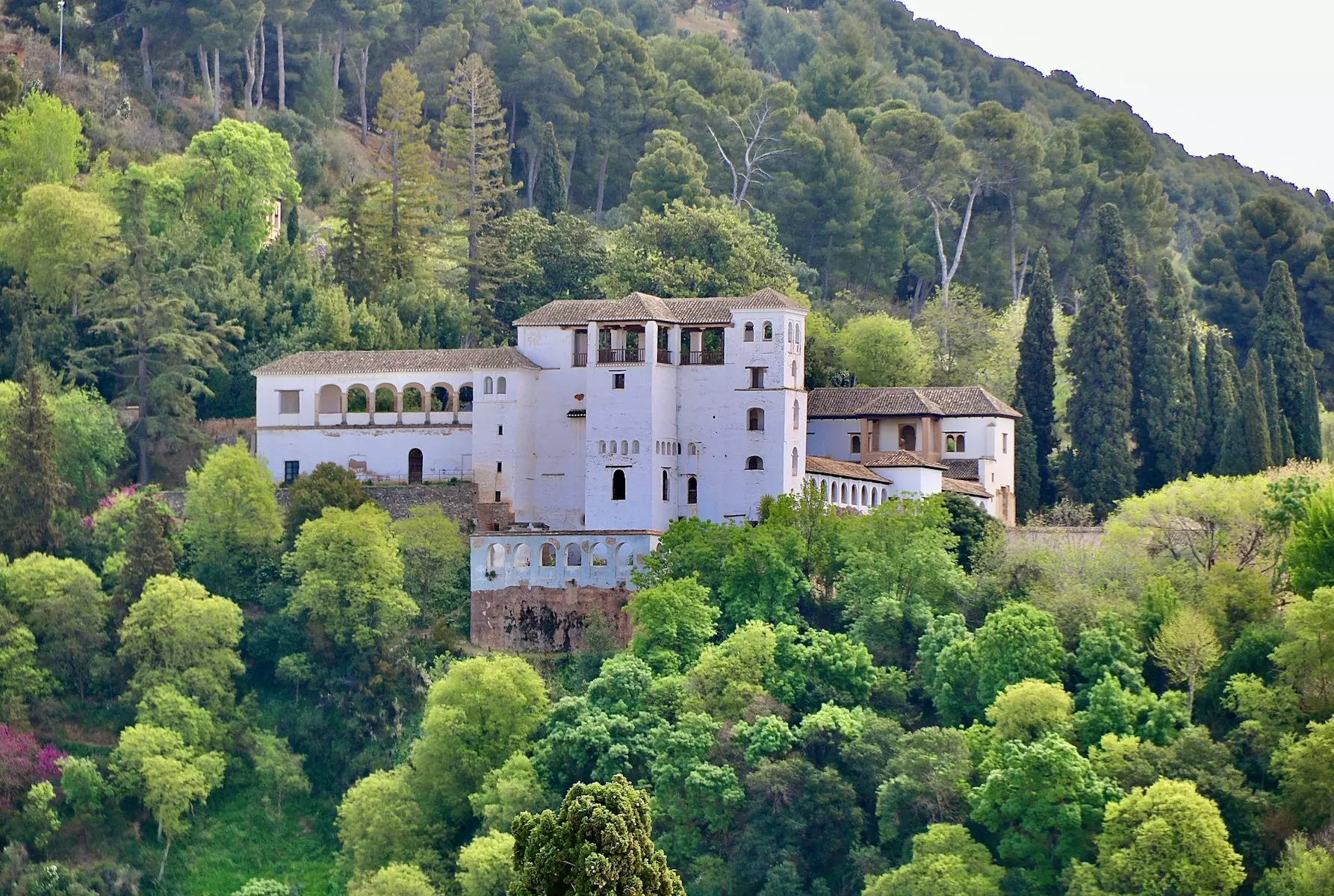 white concrete building surrounded by green trees during daytime