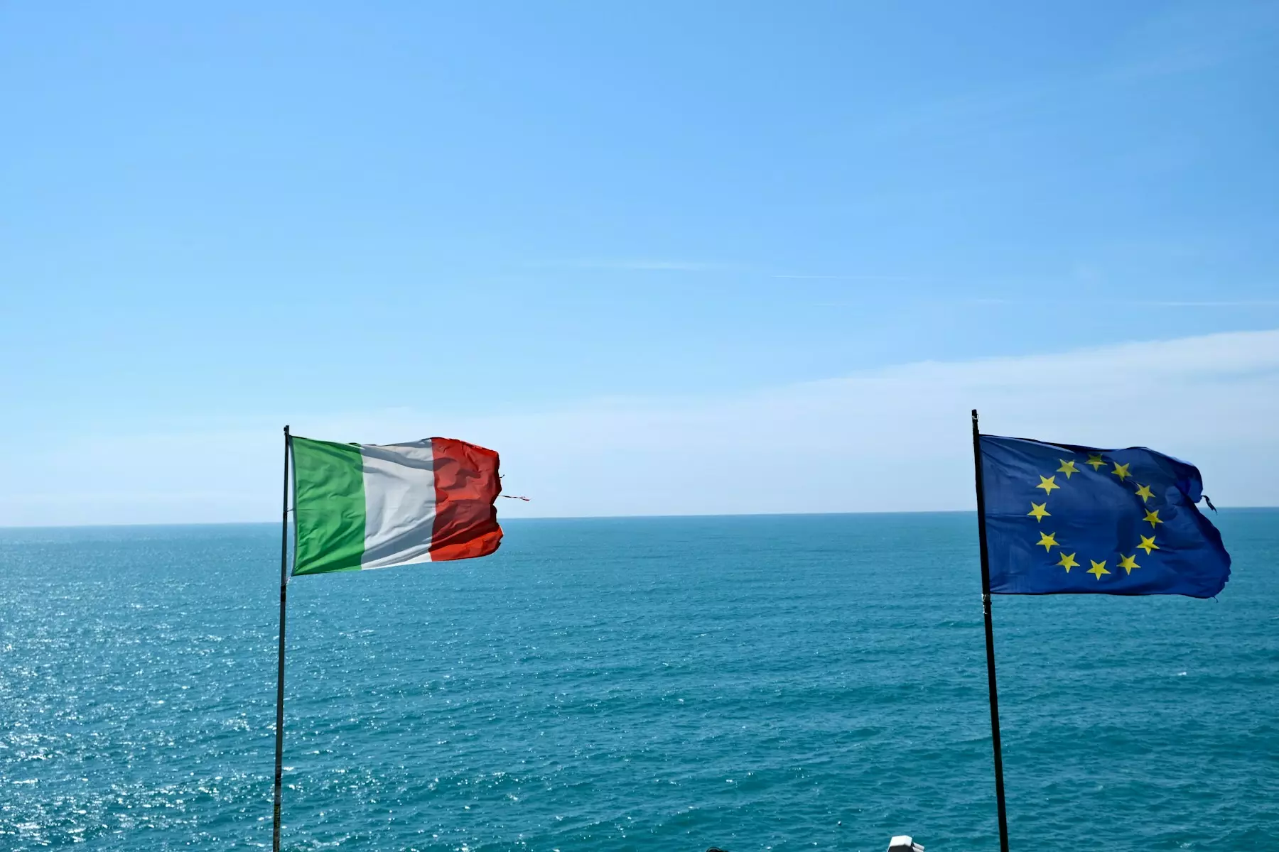 flags on poles in the water