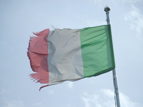 a flag flying in the wind with a sky background