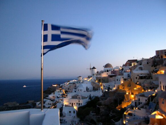 Flag of Greece waving at pole at Santorino, Greece