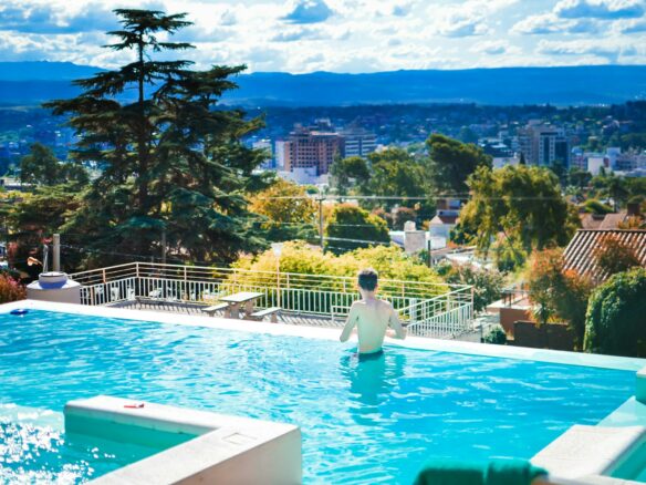 a person standing in a swimming pool with a view of a city