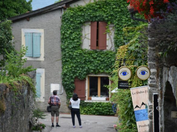 A couple of people walking down a street next to a building