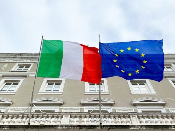 two flags are flying in front of a building