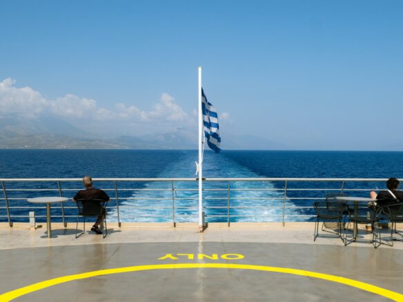 Two people sitting on a bench on a cruise ship