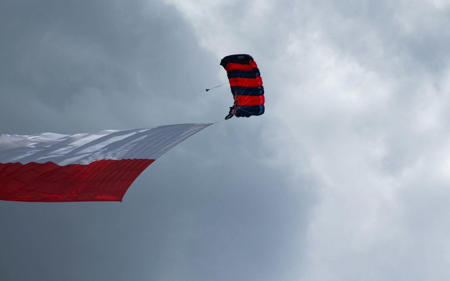 a red, white and blue kite flying in the sky