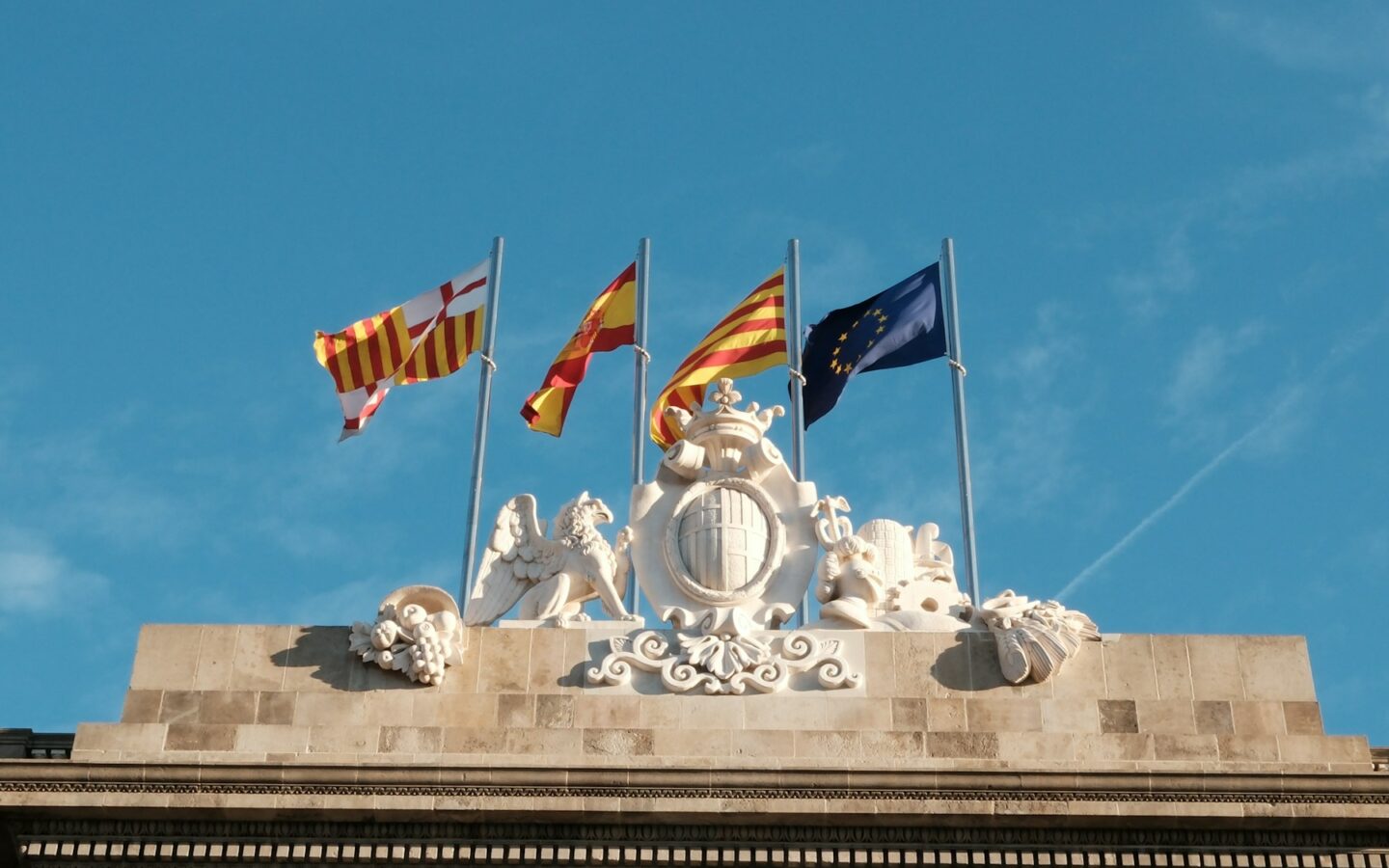 A group of flags flying on top of a building