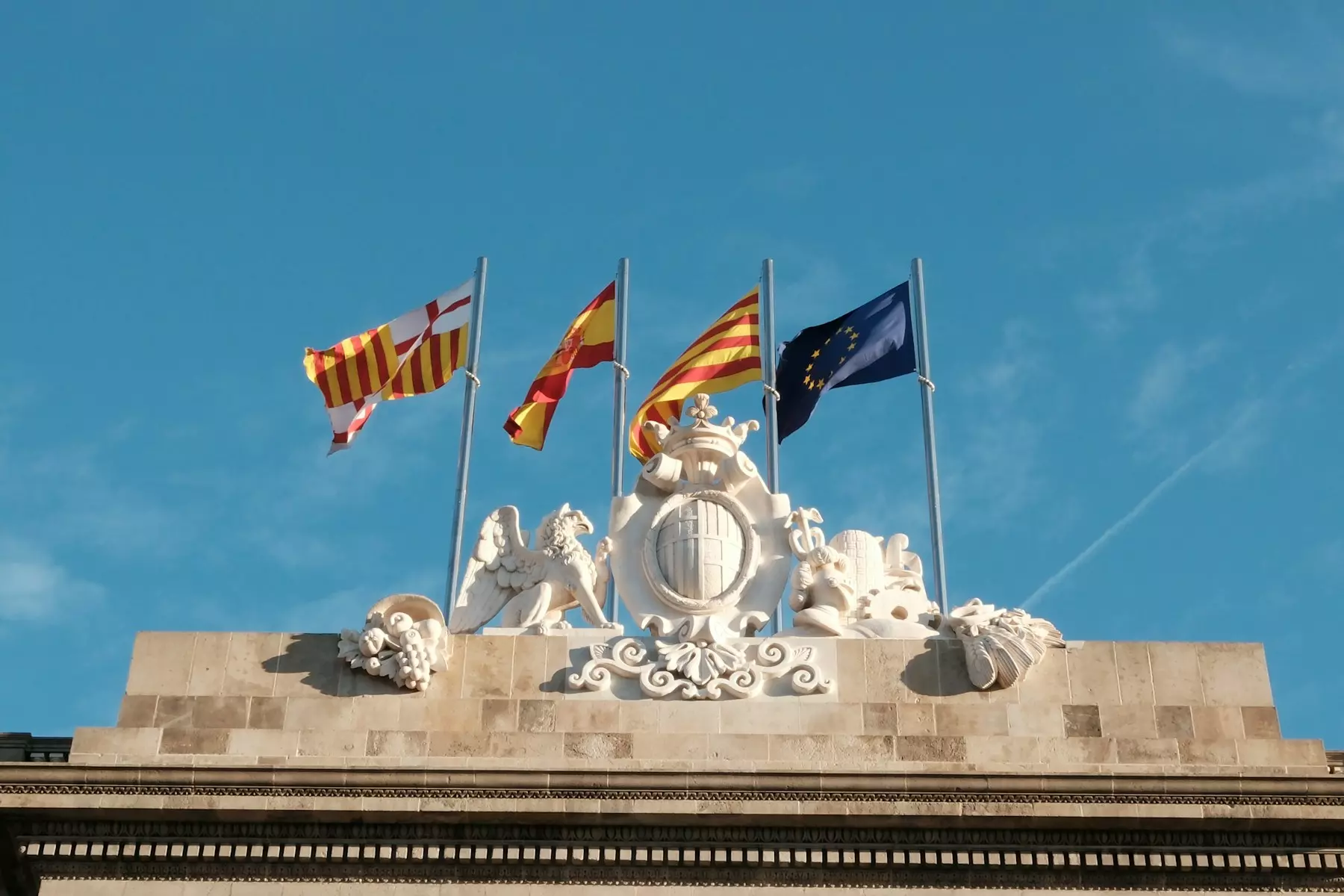 A group of flags flying on top of a building