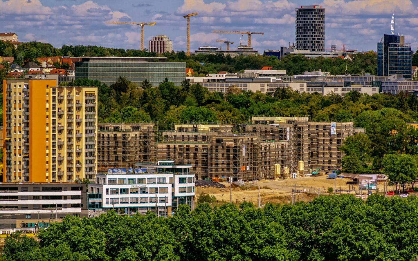 Cityscape with buildings and construction cranes.