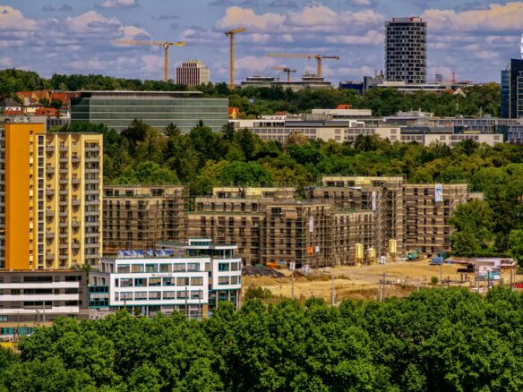 Városkép épületekkel és építőipari darukkal.