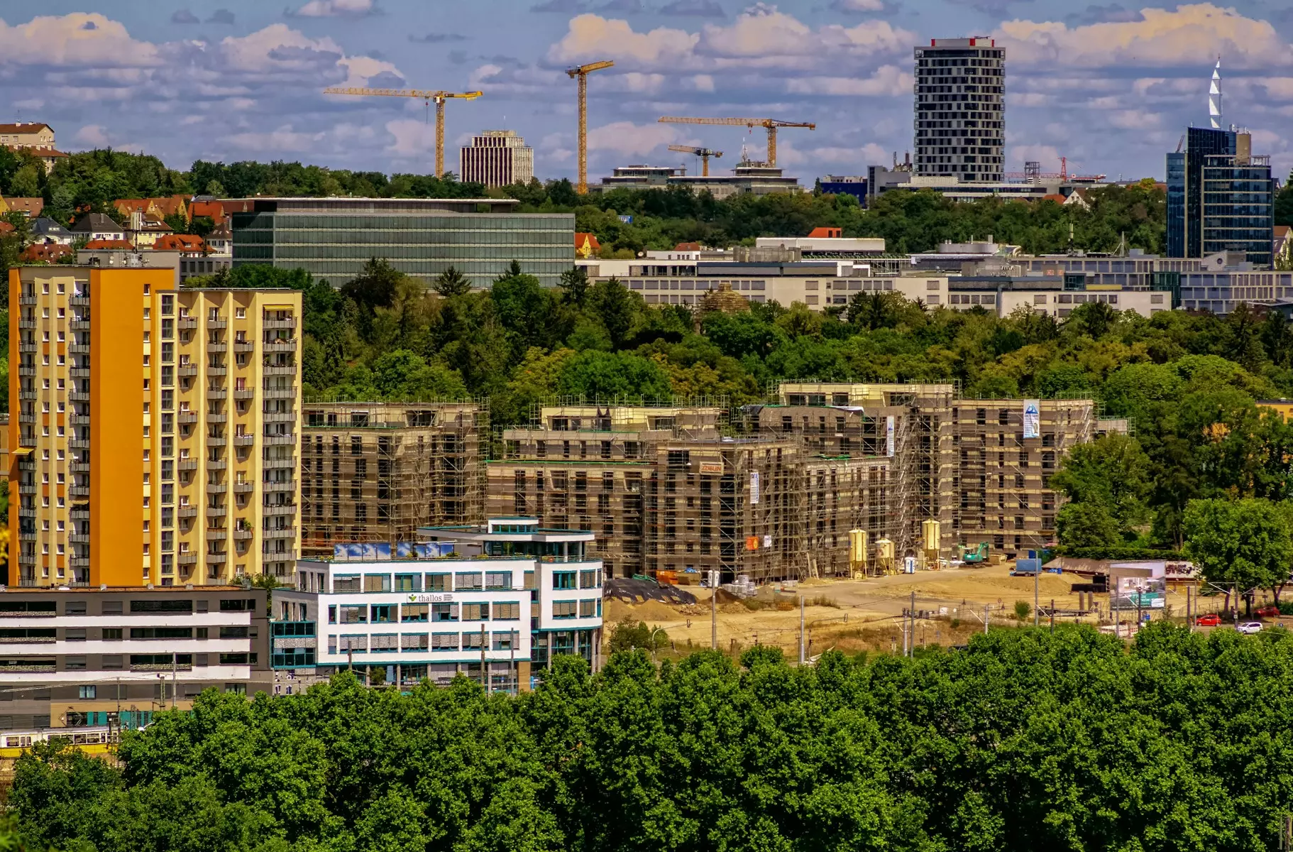 Cityscape with buildings and construction cranes.