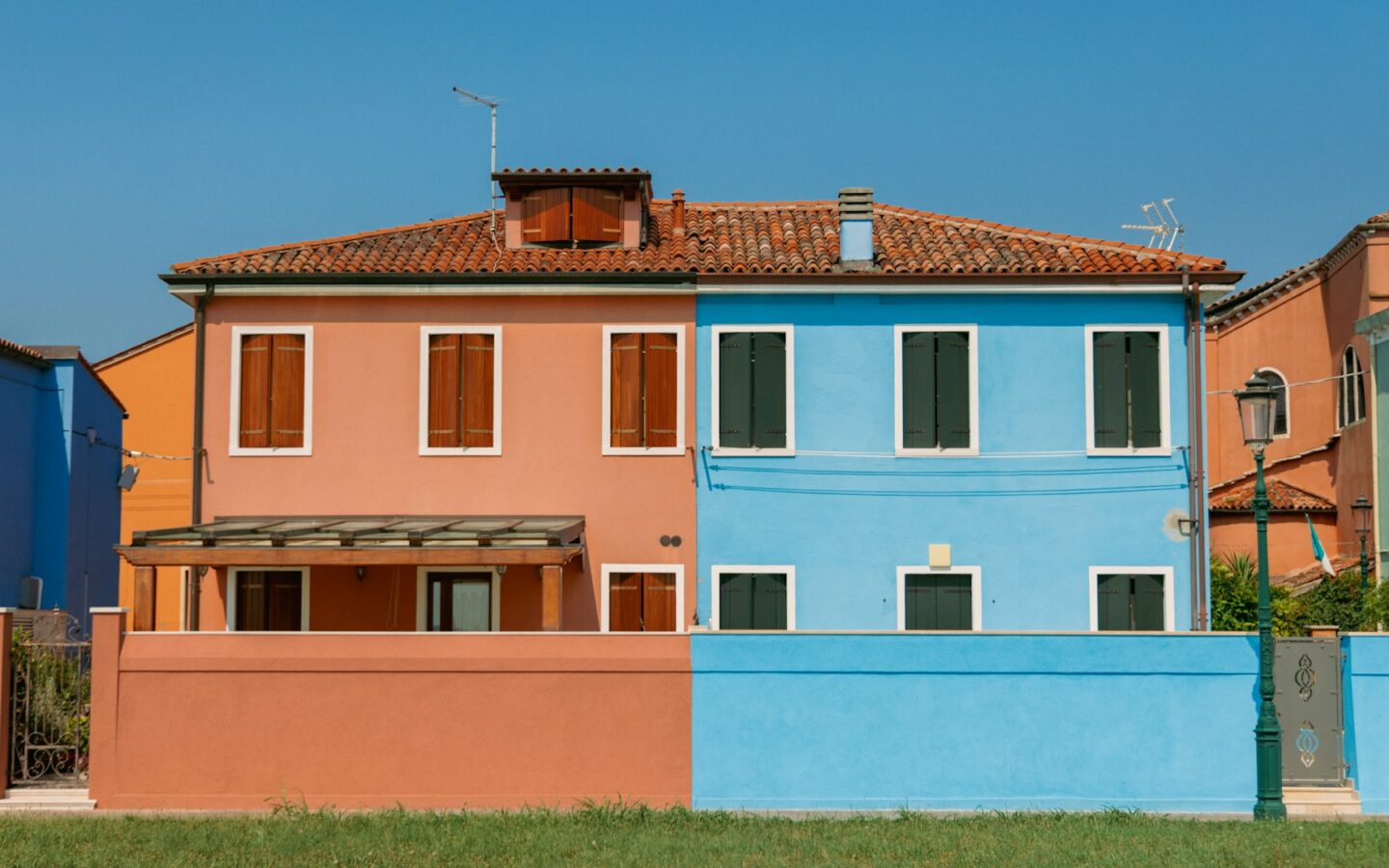 a blue and pink house next to each other