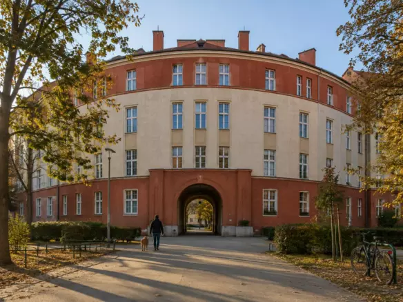 A municipal apartment block in Vienna, seen from the street in late afternoon light (illustration)