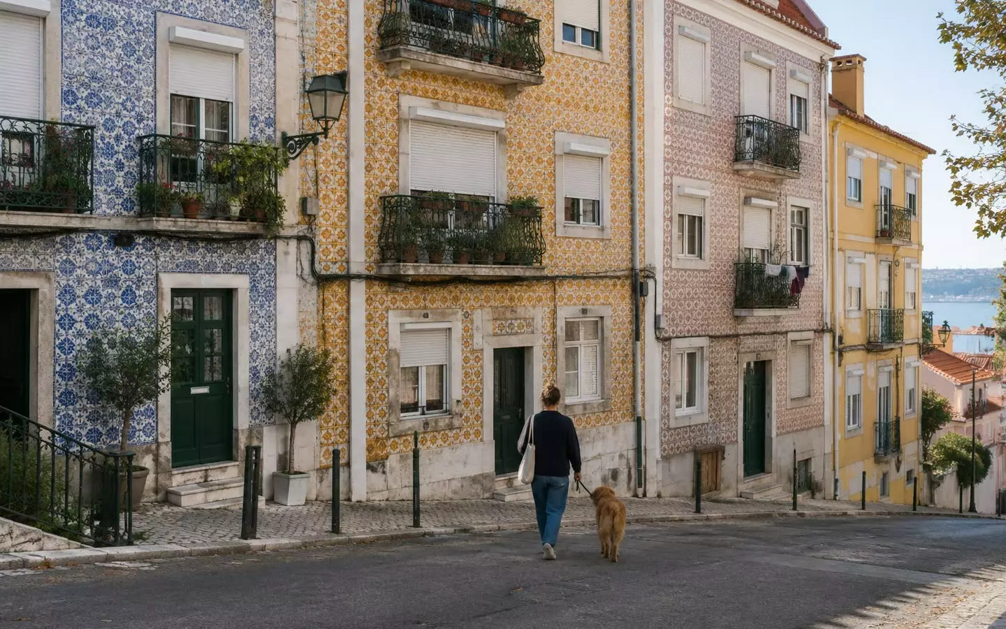 A residential street of tiled facades and iron balconies in Lisbon on a mild autumn morning (illustration)