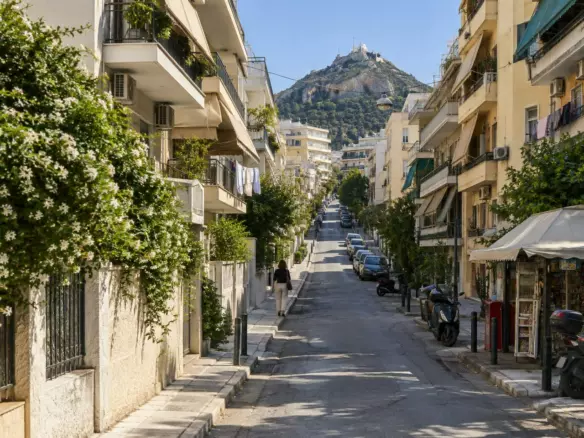A rising Athens street of 1960s apartment blocks with balconies and awnings (illustration)