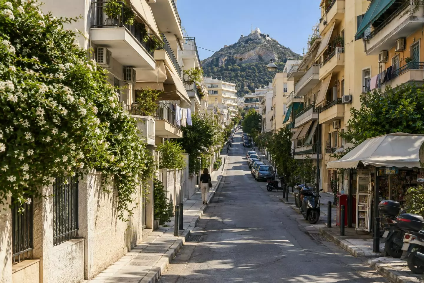 A rising Athens street of 1960s apartment blocks with balconies and awnings (illustration)