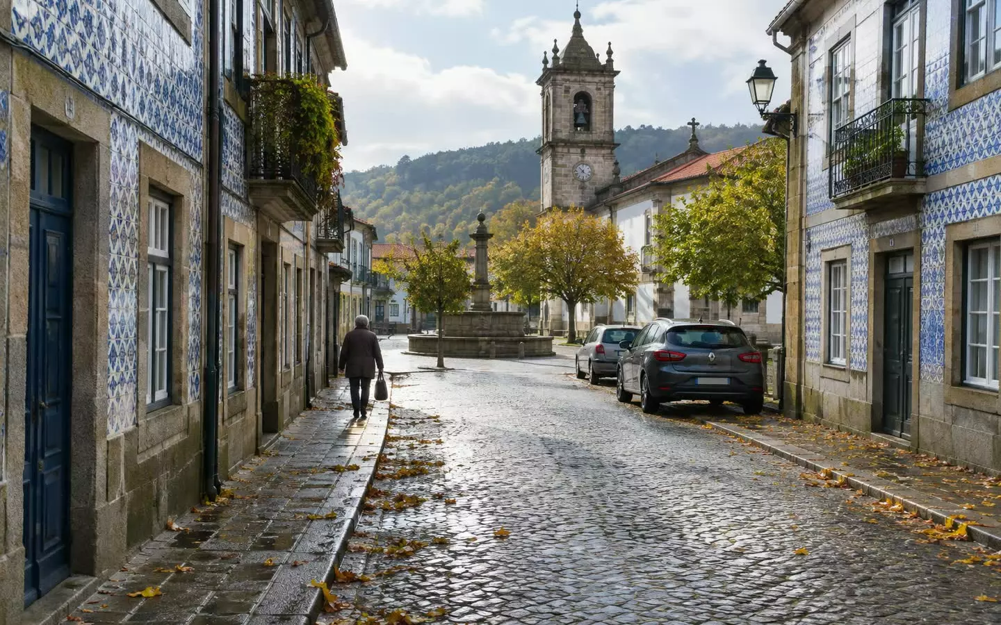 A granite street with tiled facades and a fountain in an inland Portuguese town (illustration)