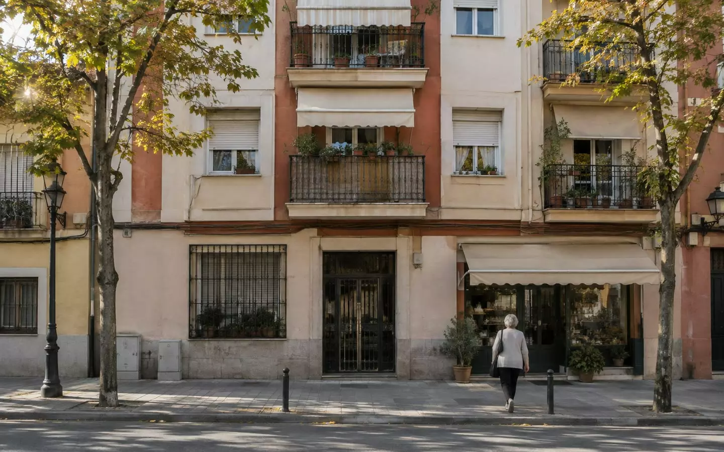 Eine Wohnstraße mit mittelhohen Wohnhäusern mit schmiedeeisernen Balkonen, Persianas und Markisen in Madrid an einem milden Frühherbstmorgen (Illustration)