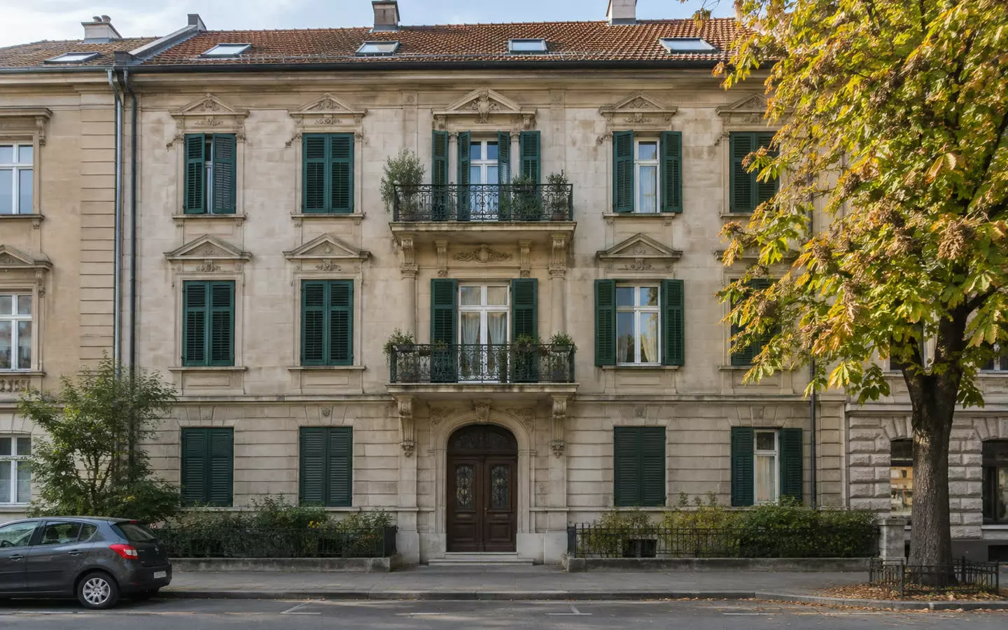 Ein steinernes Wohnhaus mit grünen Fensterläden und Ziegeldach in einer ruhigen Straße in Zagreb im Frühherbst (Illustration).