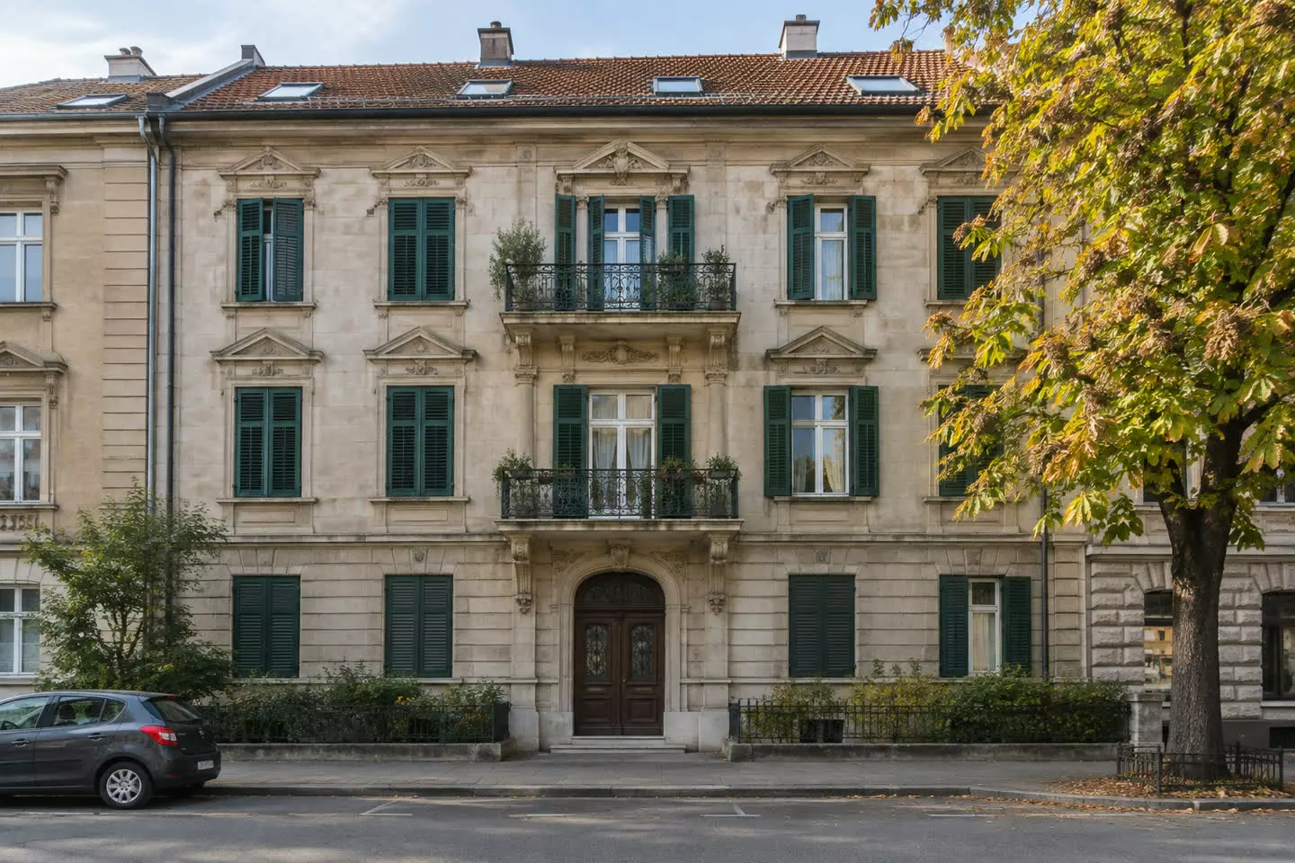 A stone apartment building with green shutters and a tiled roof on a quiet street in Zagreb in early autumn (illustration)