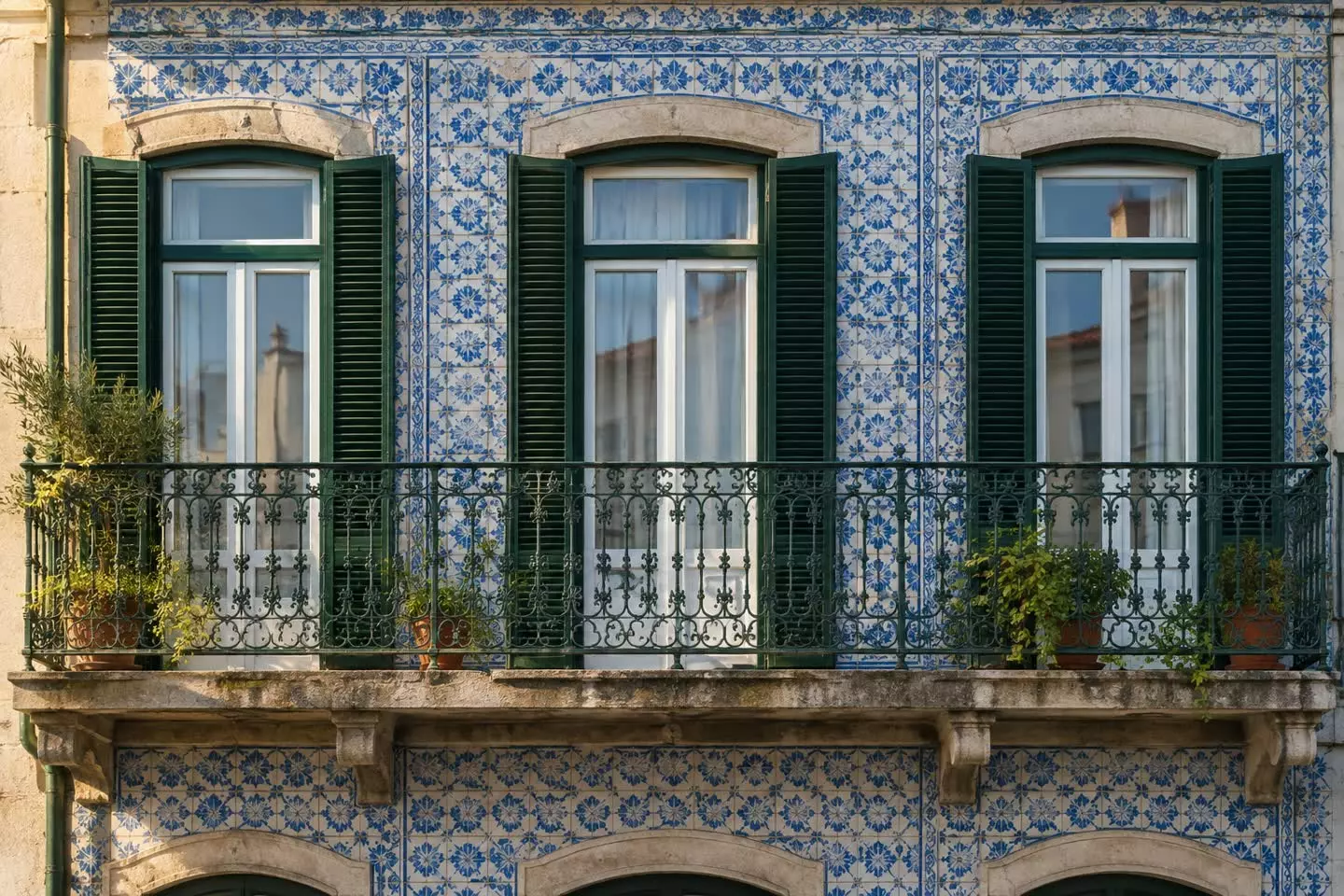 A Lisbon building facade with blue and white azulejo tiles and a wrought-iron balcony in early autumn (illustration)