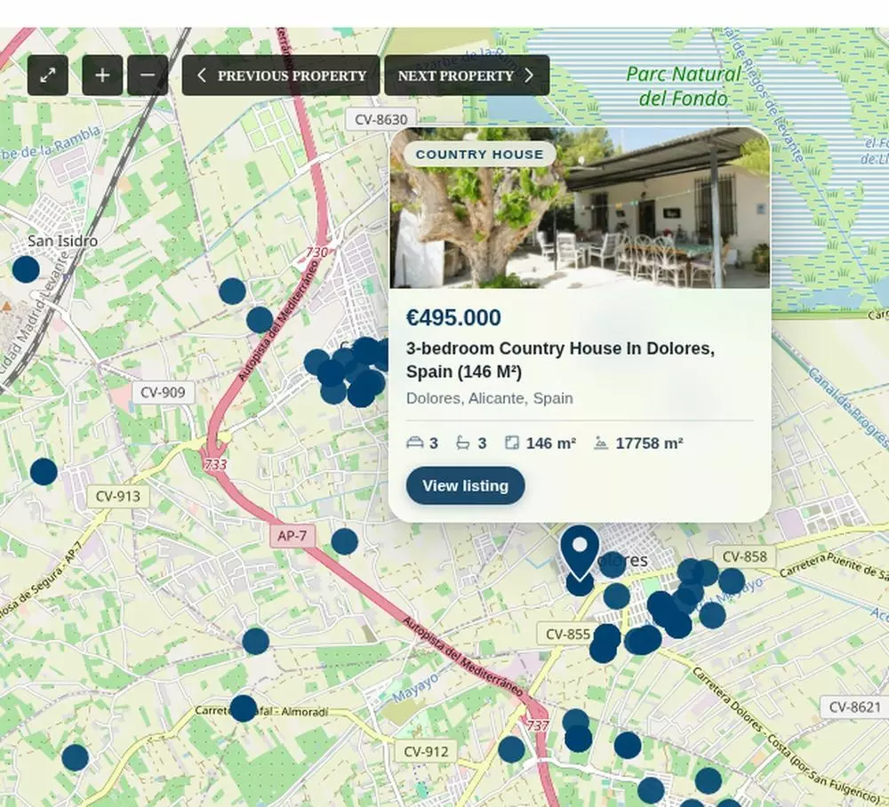 The search map over Alicante with dark blue dots and one property card open showing the price, the address and a View listing link, with a pin on the exact location (product screenshot)